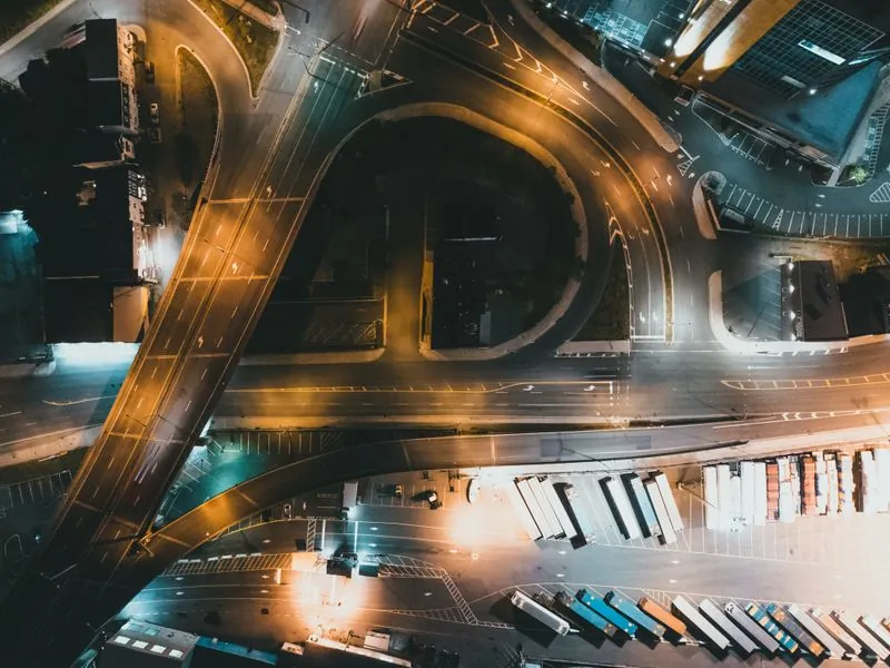 Night aerial view of a motorway junction with light trails